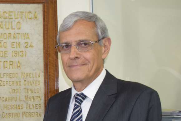 Imagem mostra rosto do Dr. Luiz Fernando Pellegrino, homem branco com cabelos brancos, usando óculos e vestindo terno cinza escuros com gravata listrada