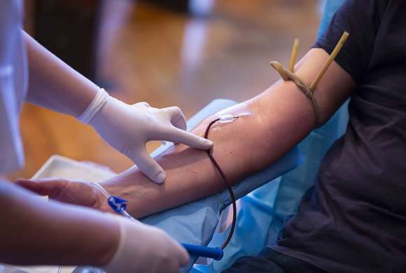 Profissional de Saúde faz coleta de sangue em paciente