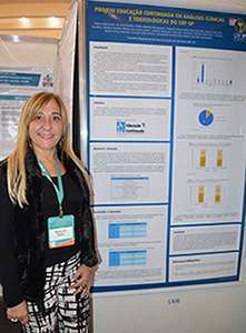 Dra. Raquel Rizzi, vice-presidente do CRF-SP, ao lado do trabalho científico elaborado pelo CRF-SP por meio da Comissão Assessora de Análises Clínicas e Toxicológicas