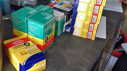 Caixas de medicamentos diversos colocados em prateleira de armário
