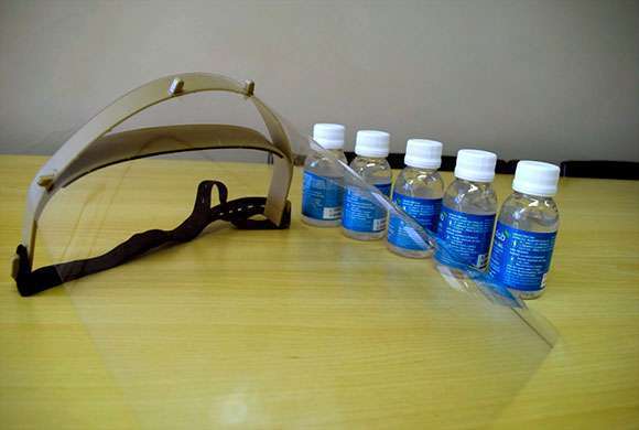 Um protetor facial do tipo faceshild e um kit com alguns vidros de álcool gel