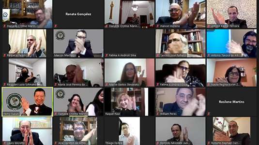 Imagem capturada da plataforma de videoconferência na qual se vê a miniatura das fotos de 25 participantes do evento, a maioria sorri e aplaude os homenageados. As pessoas são de gêneros, idades e etnias diversificadas