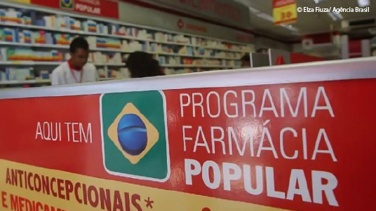Balcão de farmácia com a faixa Aqui tem Farmácia Popular 
